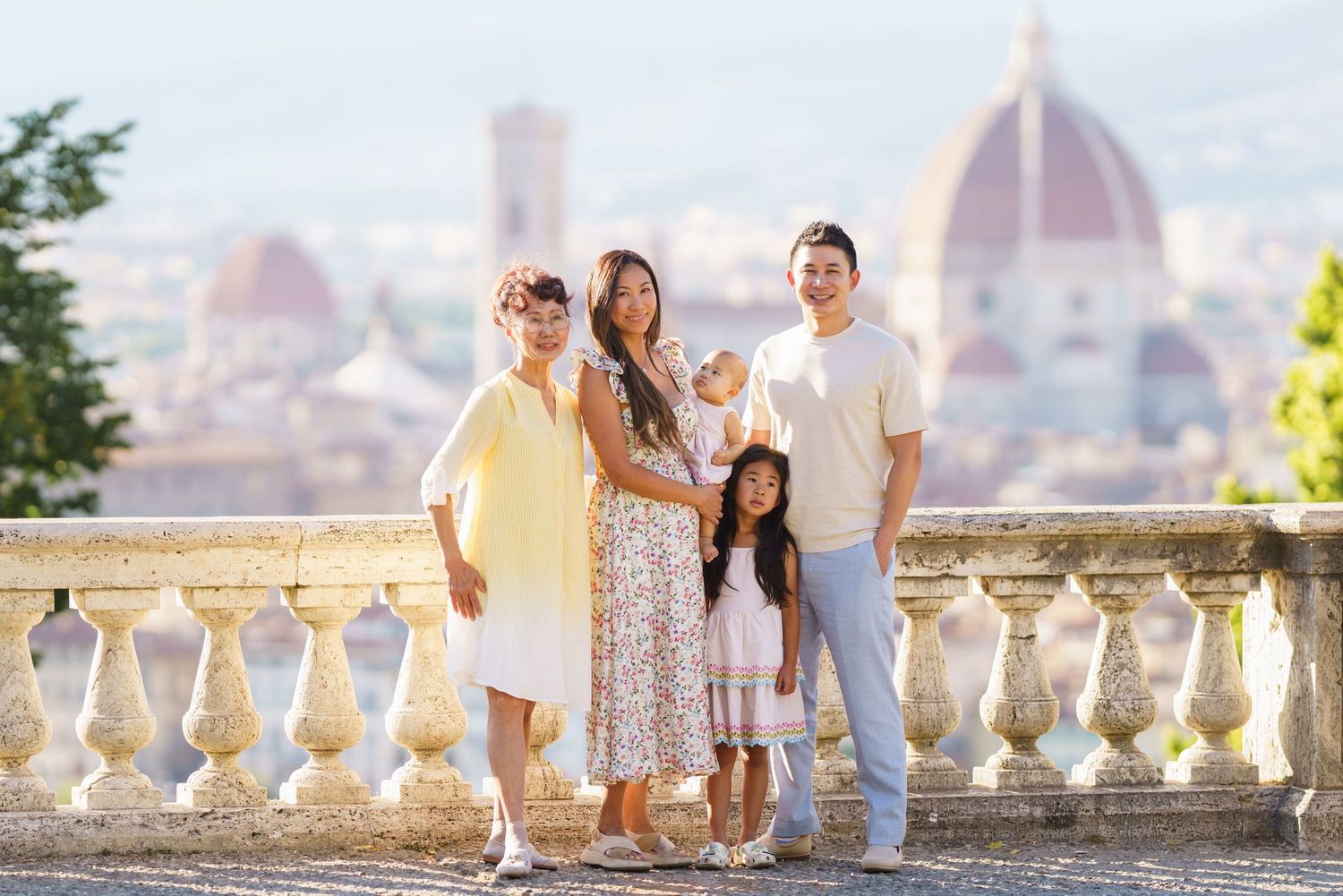 Family of five posing on a terrace in Florence, Italy, with the iconic Duomo cathedral visible in the background.