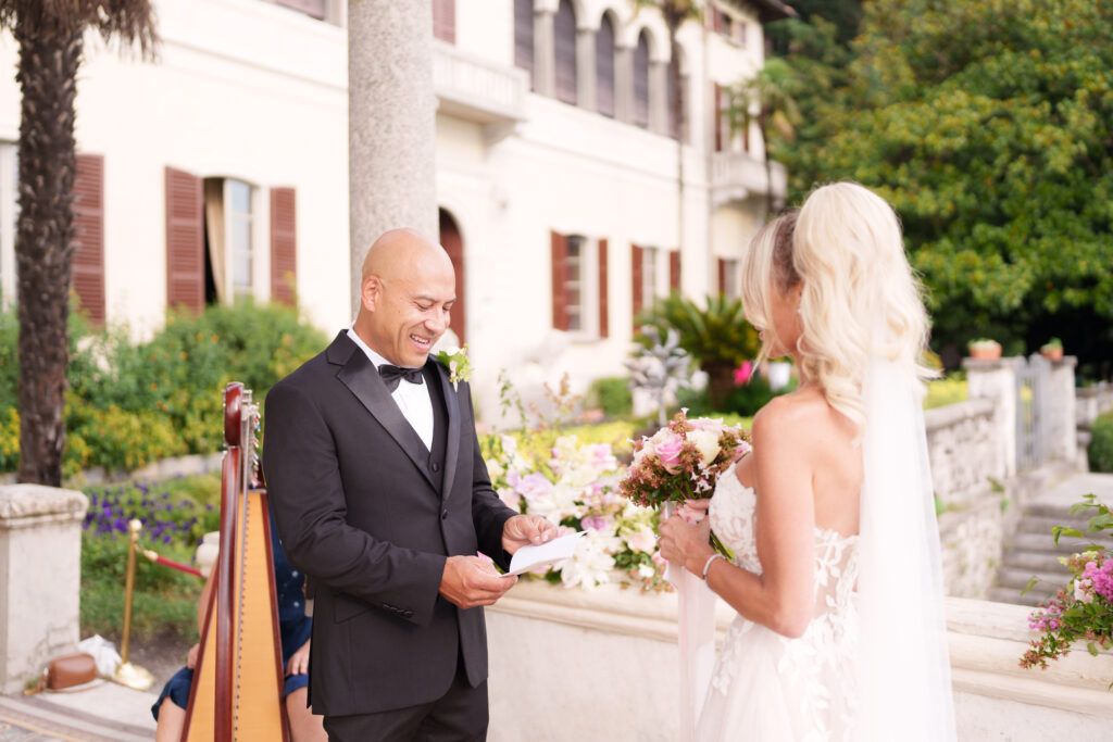 Wedding celebration on a classical Italian villa terrace with scenic mountain backdrop.