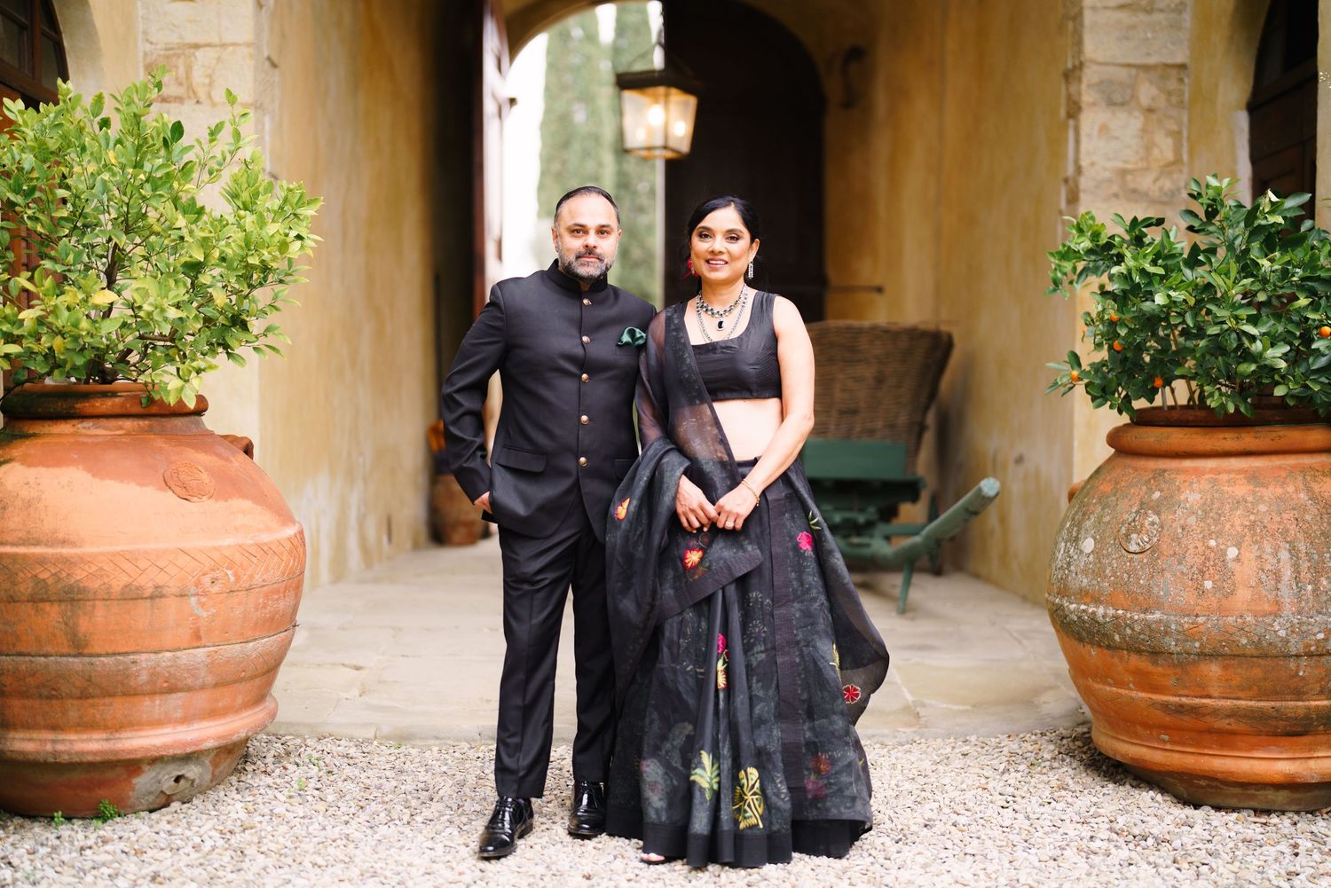 Group photo in a Mediterranean-style courtyard with stone walls and potted plants.