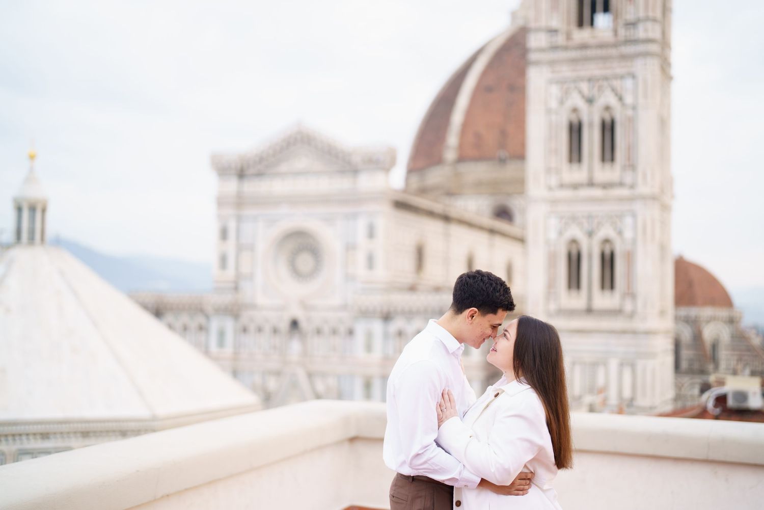 Romantic moment captured in front of Florence Cathedral's ornate marble facade.