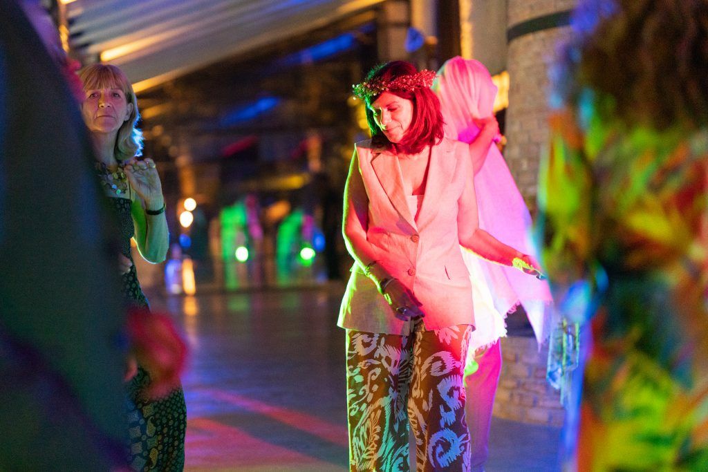Colorful dance floor lighting creates an energetic atmosphere at an evening wedding reception.