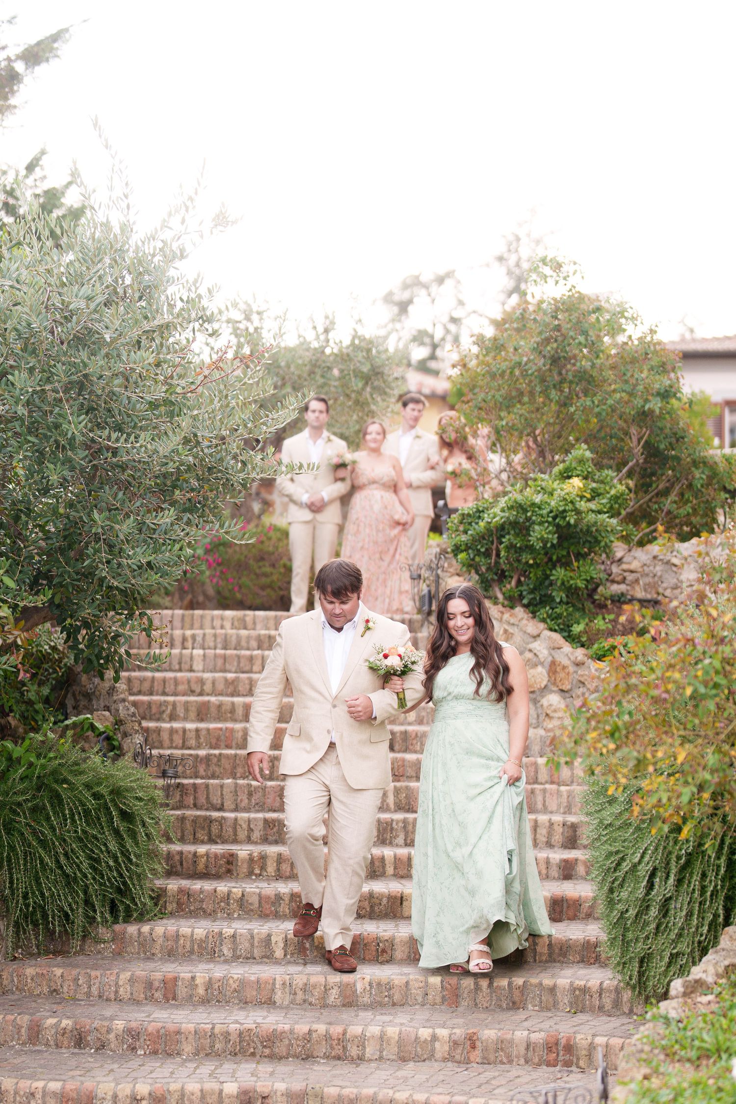 Couple in pastel outfits sitting together on outdoor brick staircase.
