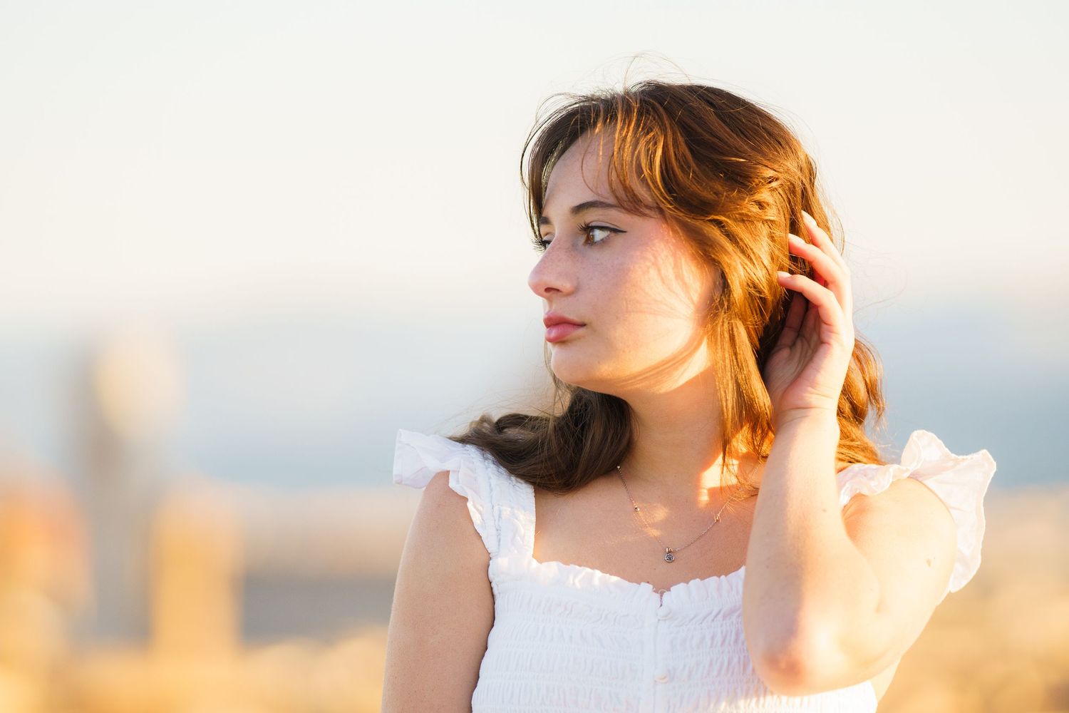 Artistic portrait series showing a woman in white dress at sunset with soft golden lighting and dreamy atmosphere.