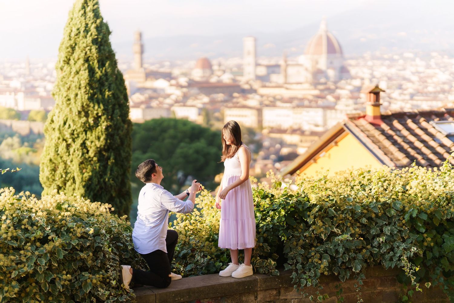 Two people enjoy a scenic overlook of Florence, Italy with the Duomo cathedral visible in the cityscape below.