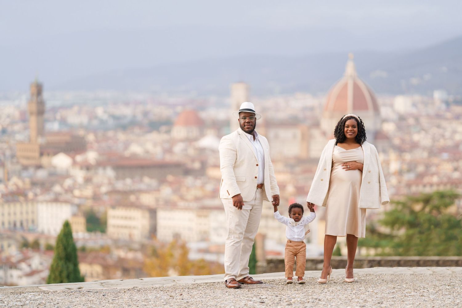 A family of three poses in front of Florence skyline with the Duomo cathedral visible in the background.