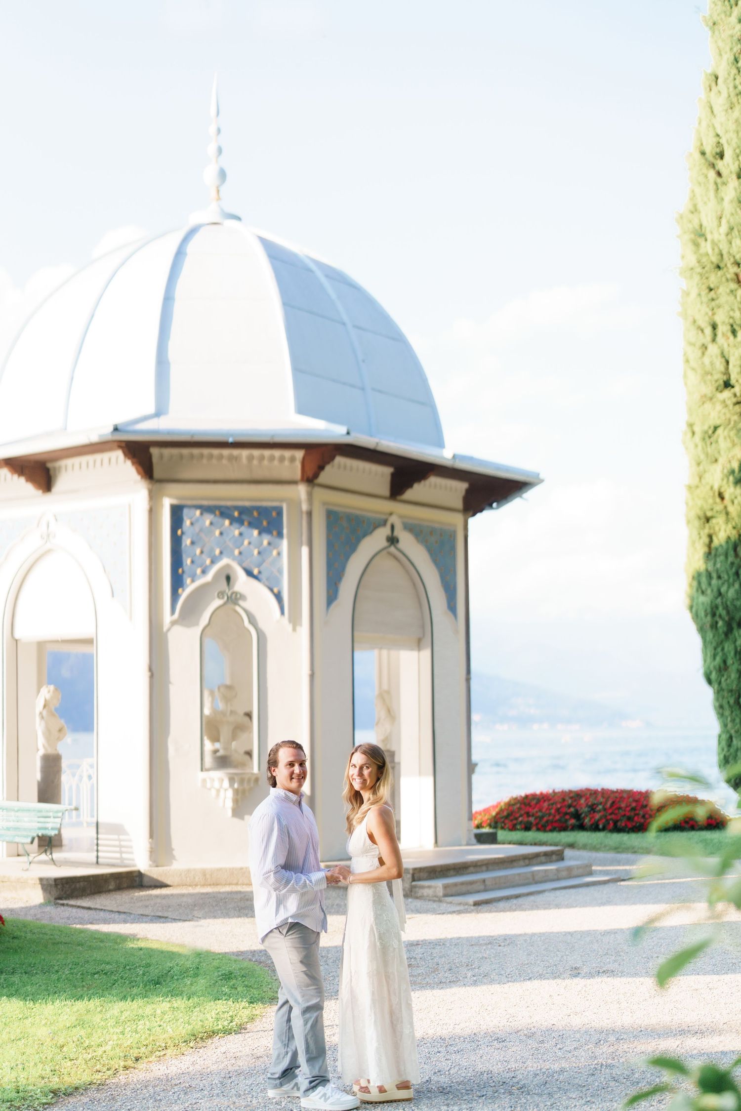 Elegant white domed gazebos line a gravel path at a romantic wedding venue overlooking scenic countryside views.