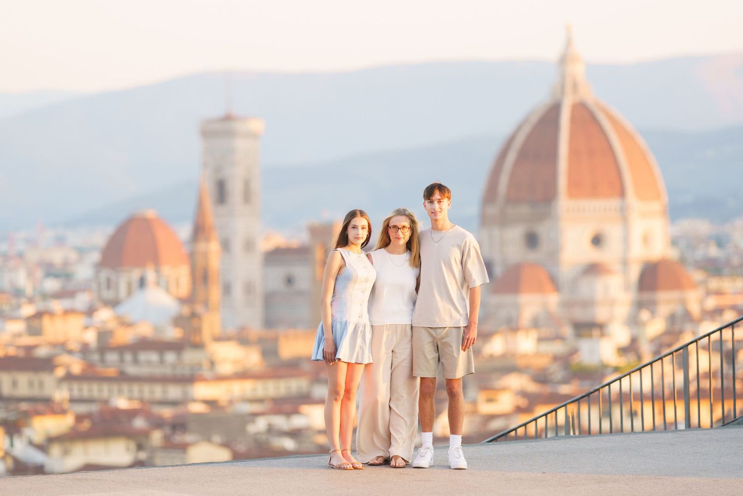 People admire the iconic Florence skyline with Duomo cathedral and historic architecture at sunset in Italy.