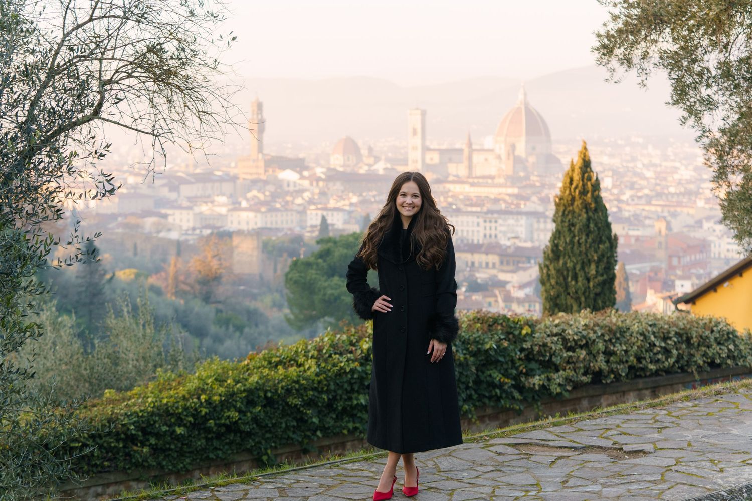 A scenic view of Florence, Italy at sunset with the city skyline and Duomo cathedral visible in the distance.