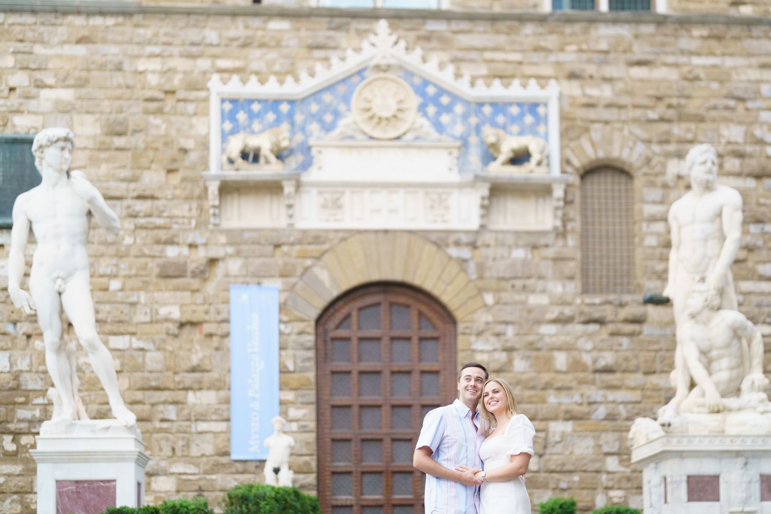 Two people pose for a photo in front of historic Palazzo Vecchio in Florence, Italy.