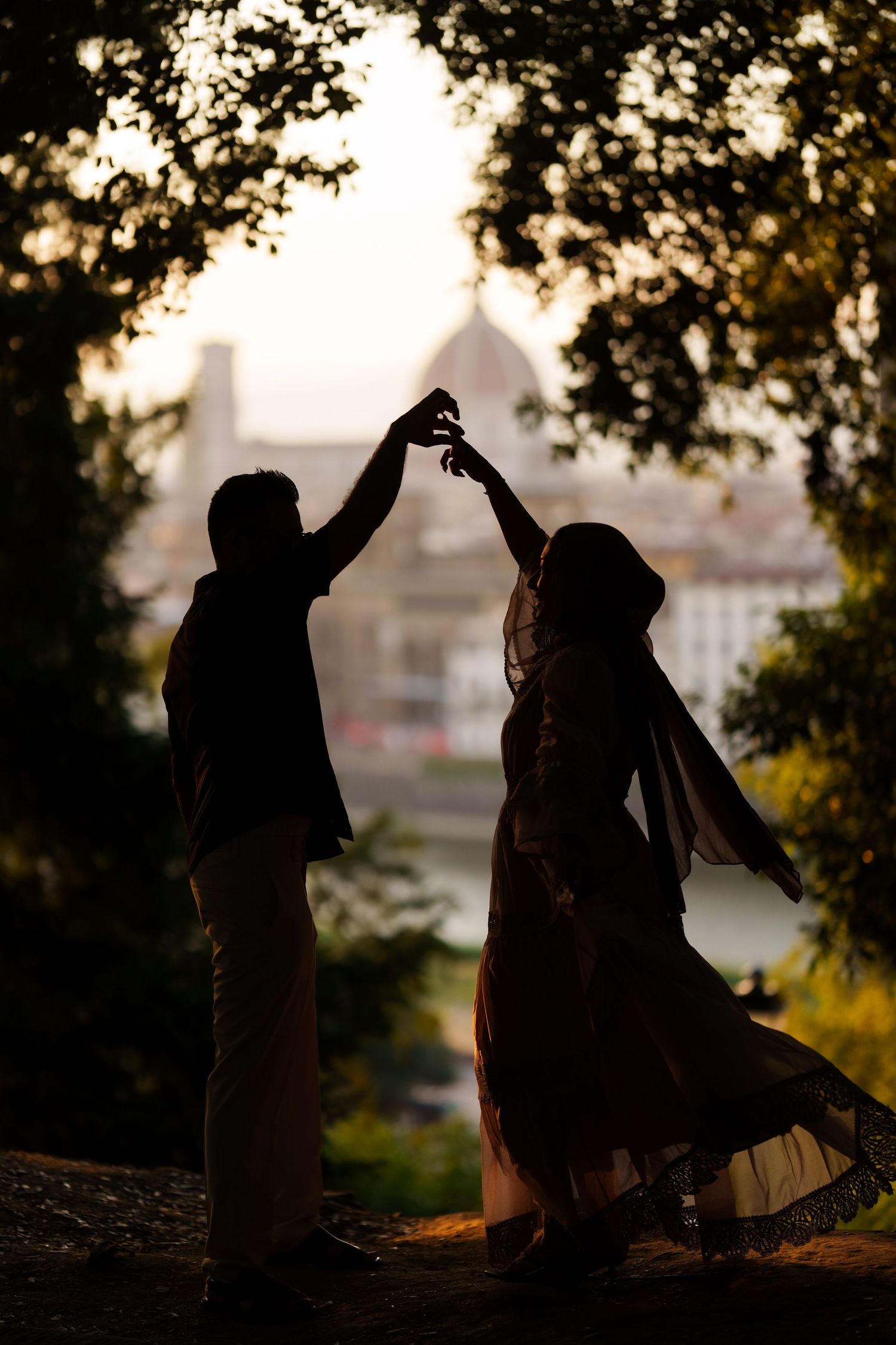 Silhouette of a couple dancing at sunset with Florence skyline and Duomo in the background.