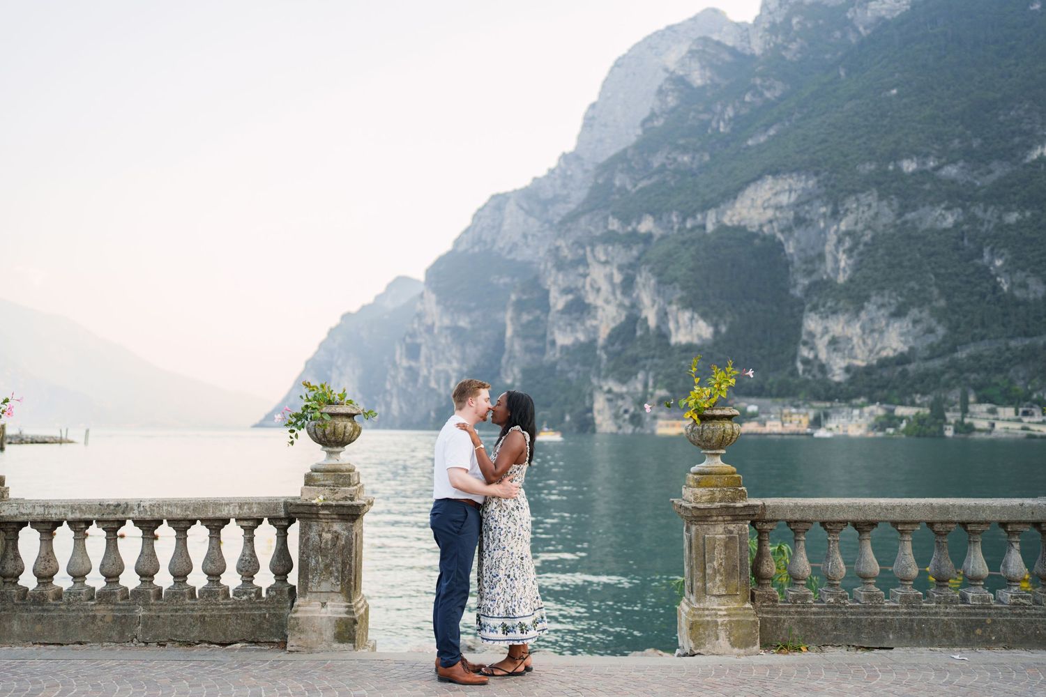 Couple walking together along the waterfront after their proposal in Riva del Garda
