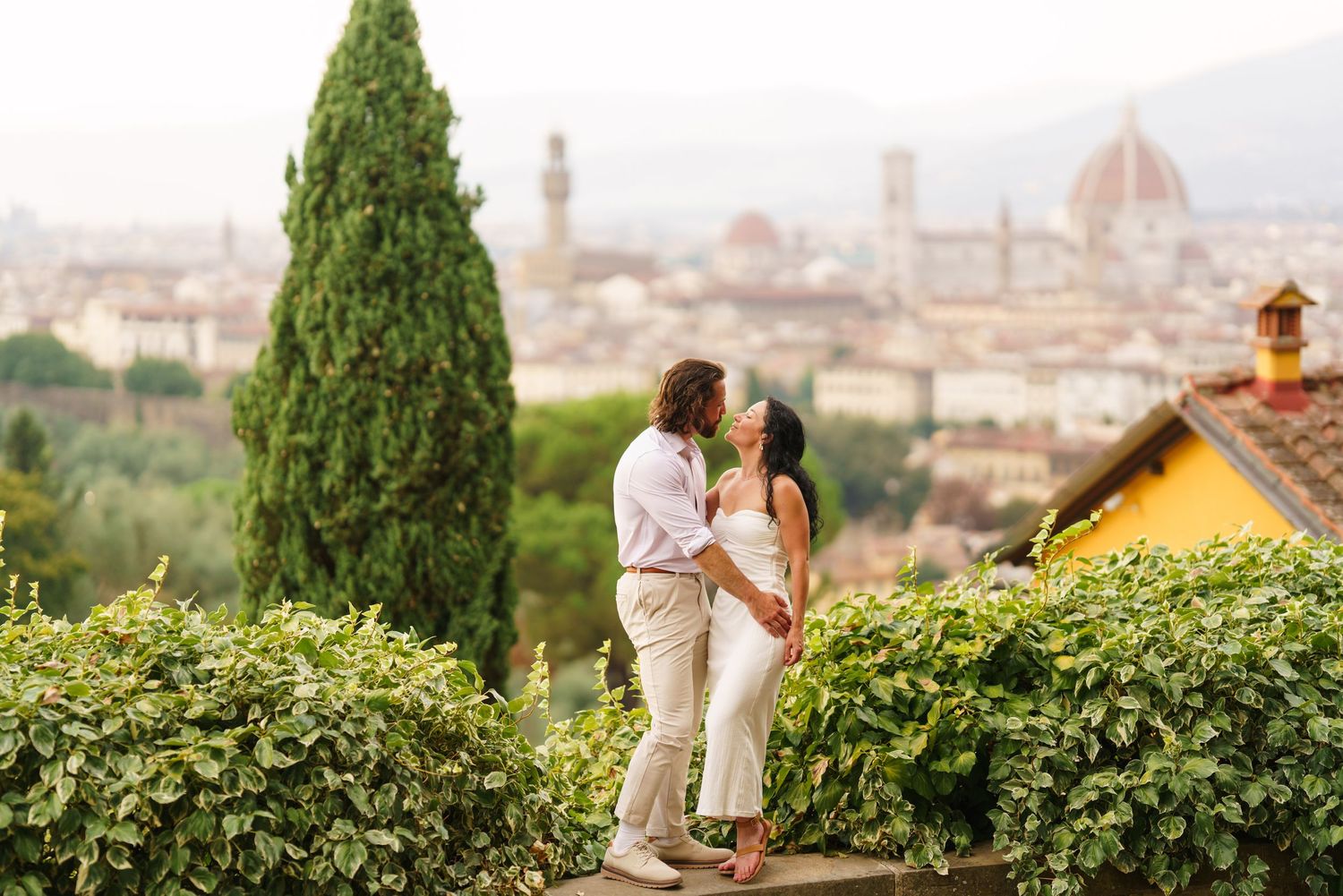 A romantic couple stands at a scenic overlook with the iconic photographer florence