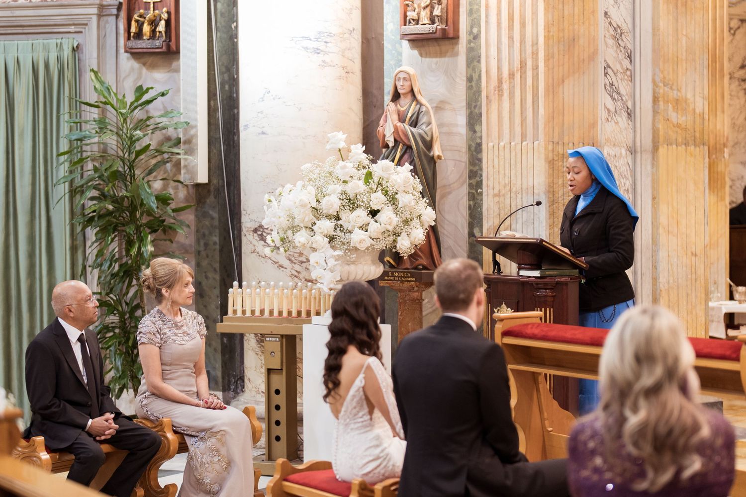 Wedding ceremony taking place in an ornate church with decorative columns and artwork.
