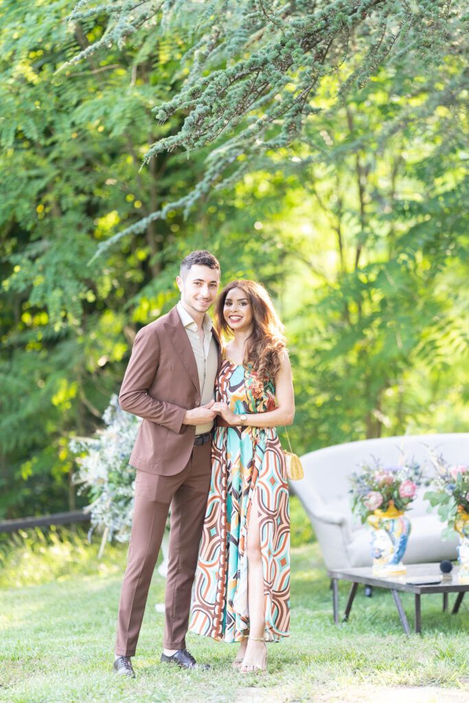 Couple laughing together on grassy lawn during outdoor celebration.