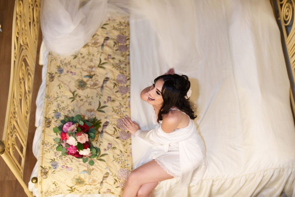 Romantic bridal preparation scene with floral details on a vintage-style couch.
