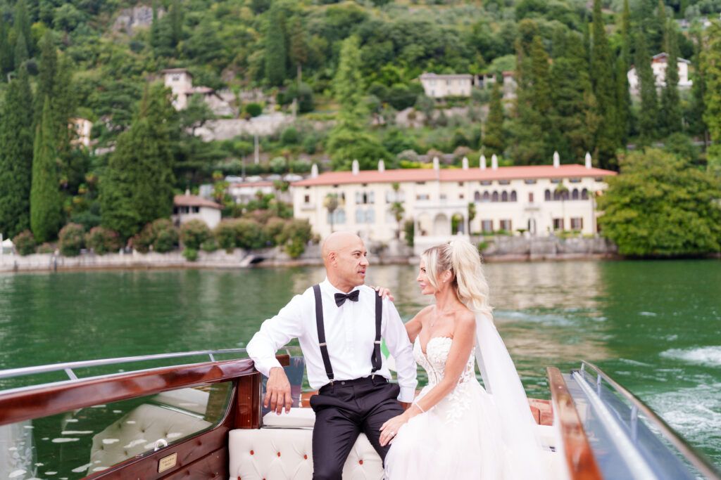 Wedding celebration on a classic wooden boat with scenic coastal mountain views.