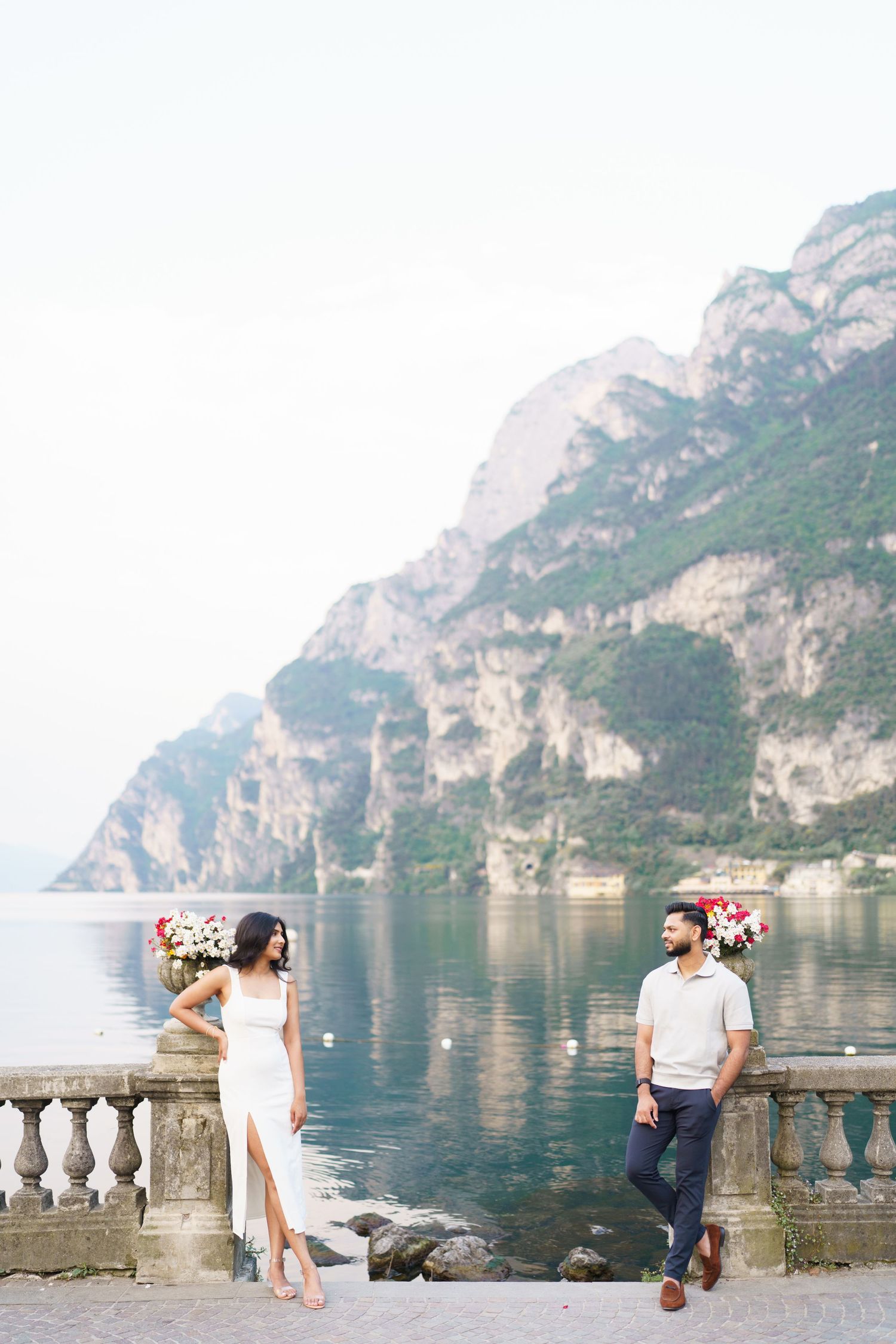 Romantic couple enjoying scenic views along Lake Como's stone balustrade terrace in Italy.