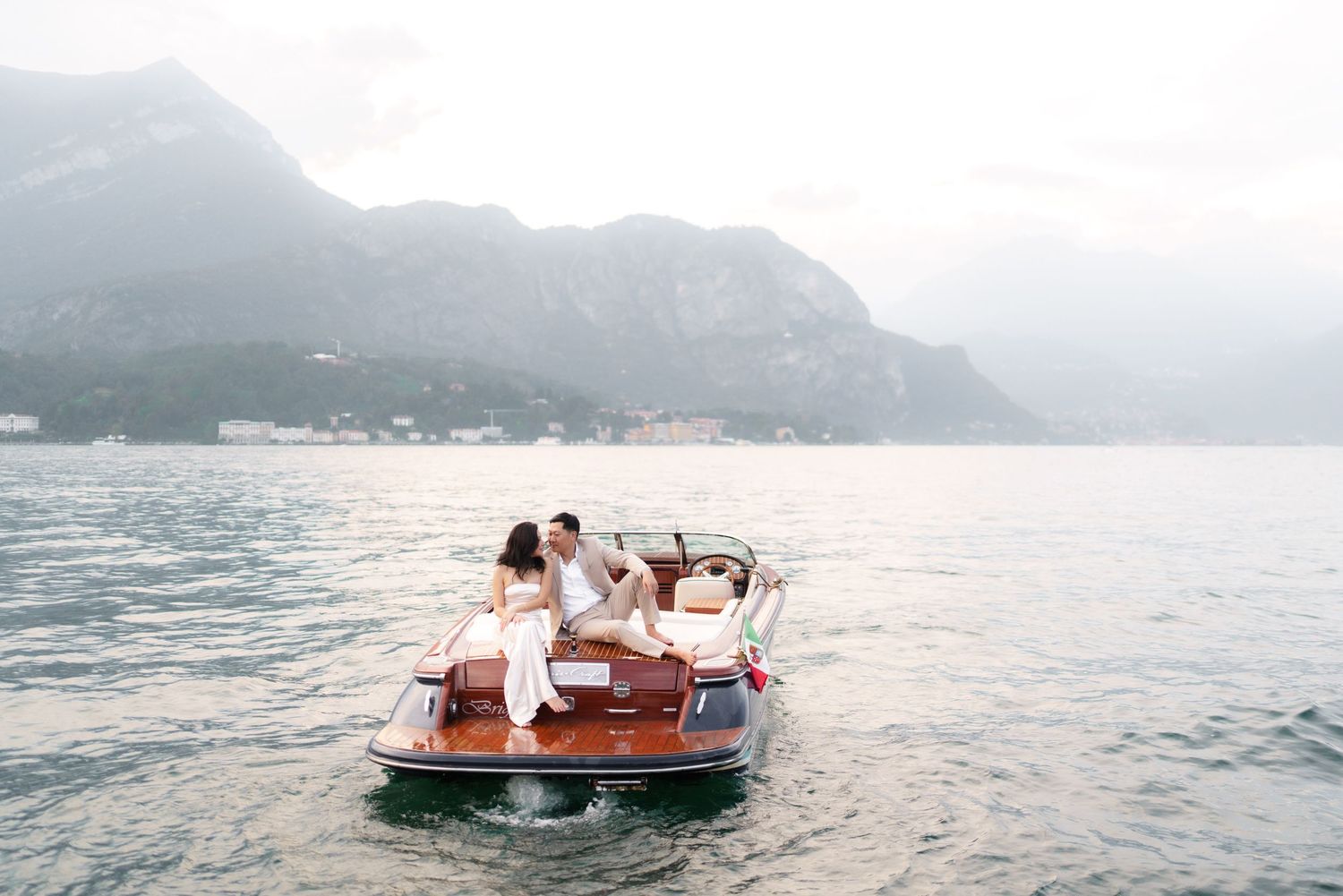 A series of photos showing a wooden boat on a misty lake surrounded by mountains during sunset.