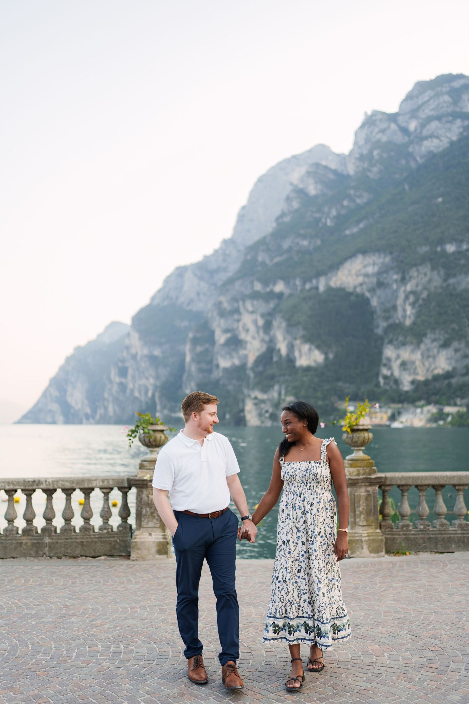 Engaged couple embracing beside Lake Garda during their Riva del Garda proposal session