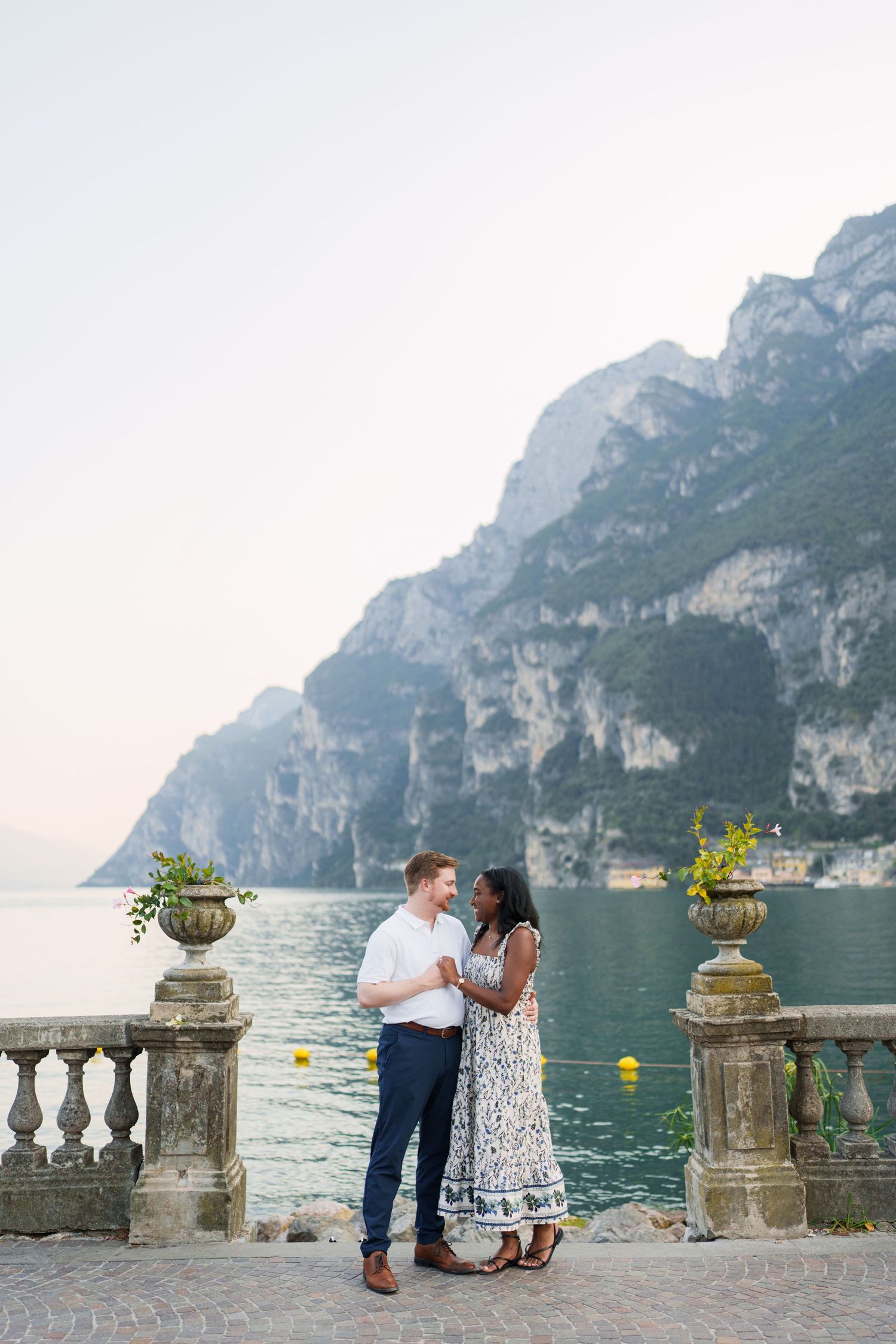 Engaged couple embracing beside Lake Garda during their Riva del Garda proposal session