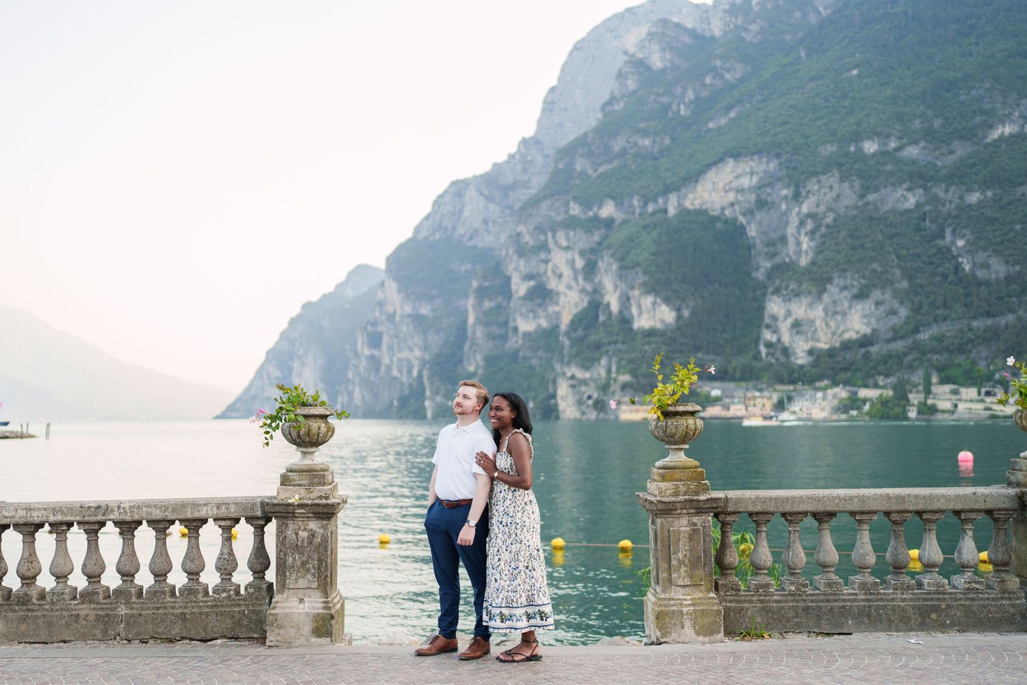 Engaged couple embracing beside Lake Garda during their Riva del Garda proposal session