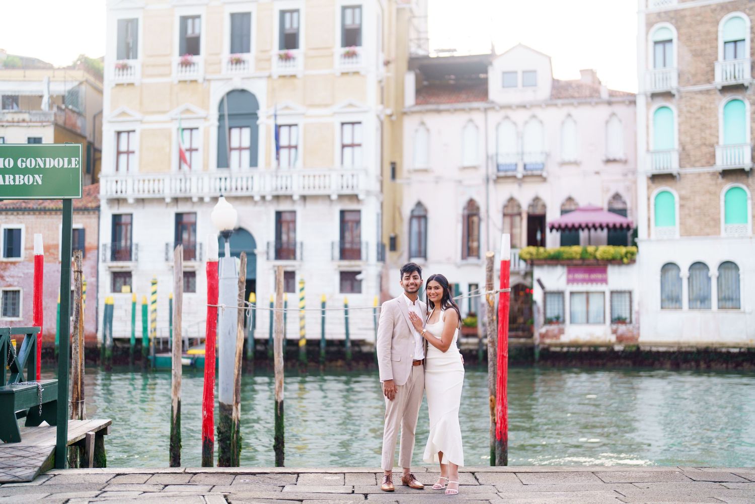 Scenic view of Venice's Grand Canal with traditional wooden poles and historic buildings reflecting in turquoise waters.
