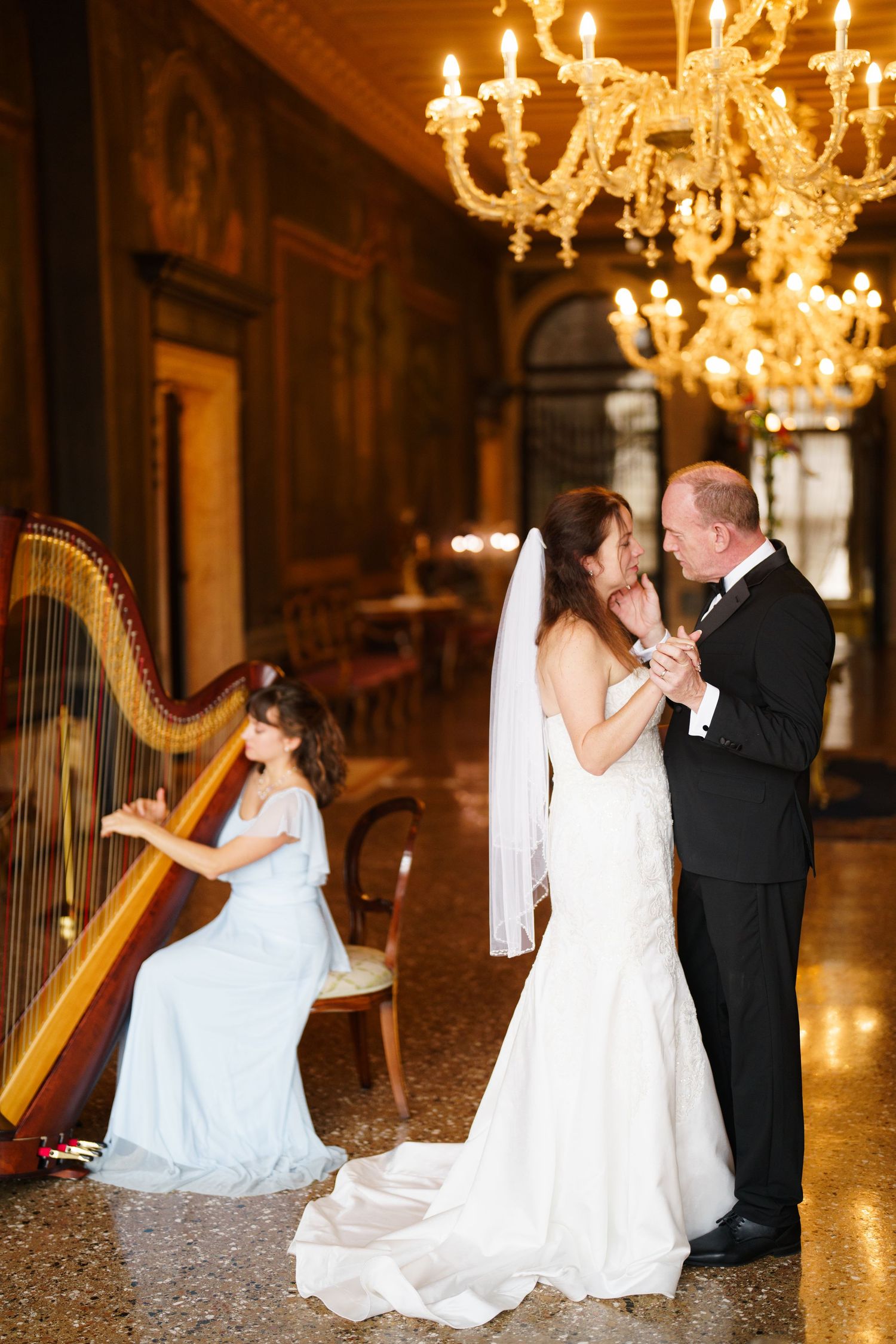 Elegant wedding photo series with couple dancing near golden chandeliers and decorative harp in ornate ballroom setting.