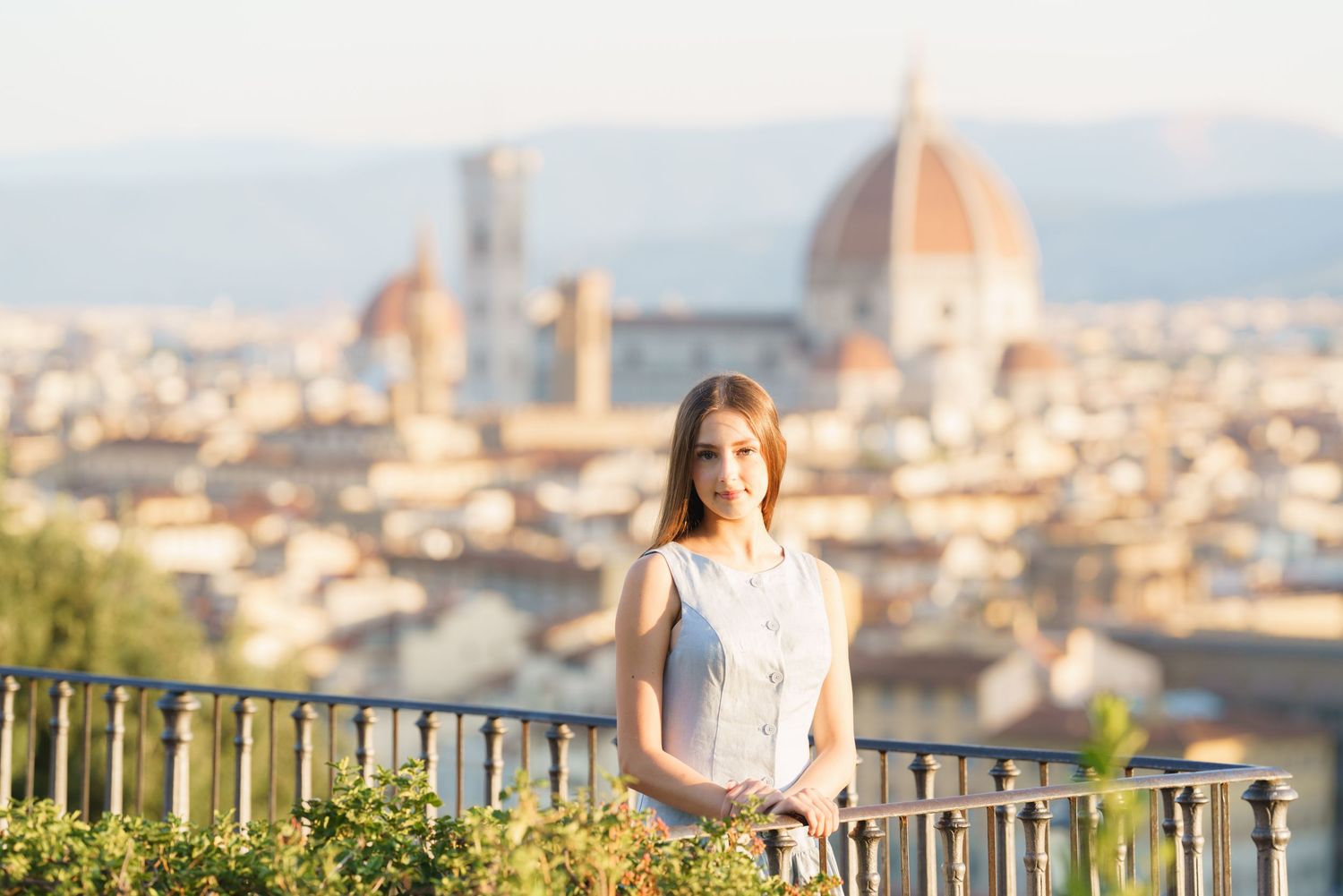 photographer Florence Woman in white dress enjoys scenic Florence cityscape view from Piazzale Michelangelo at sunset.