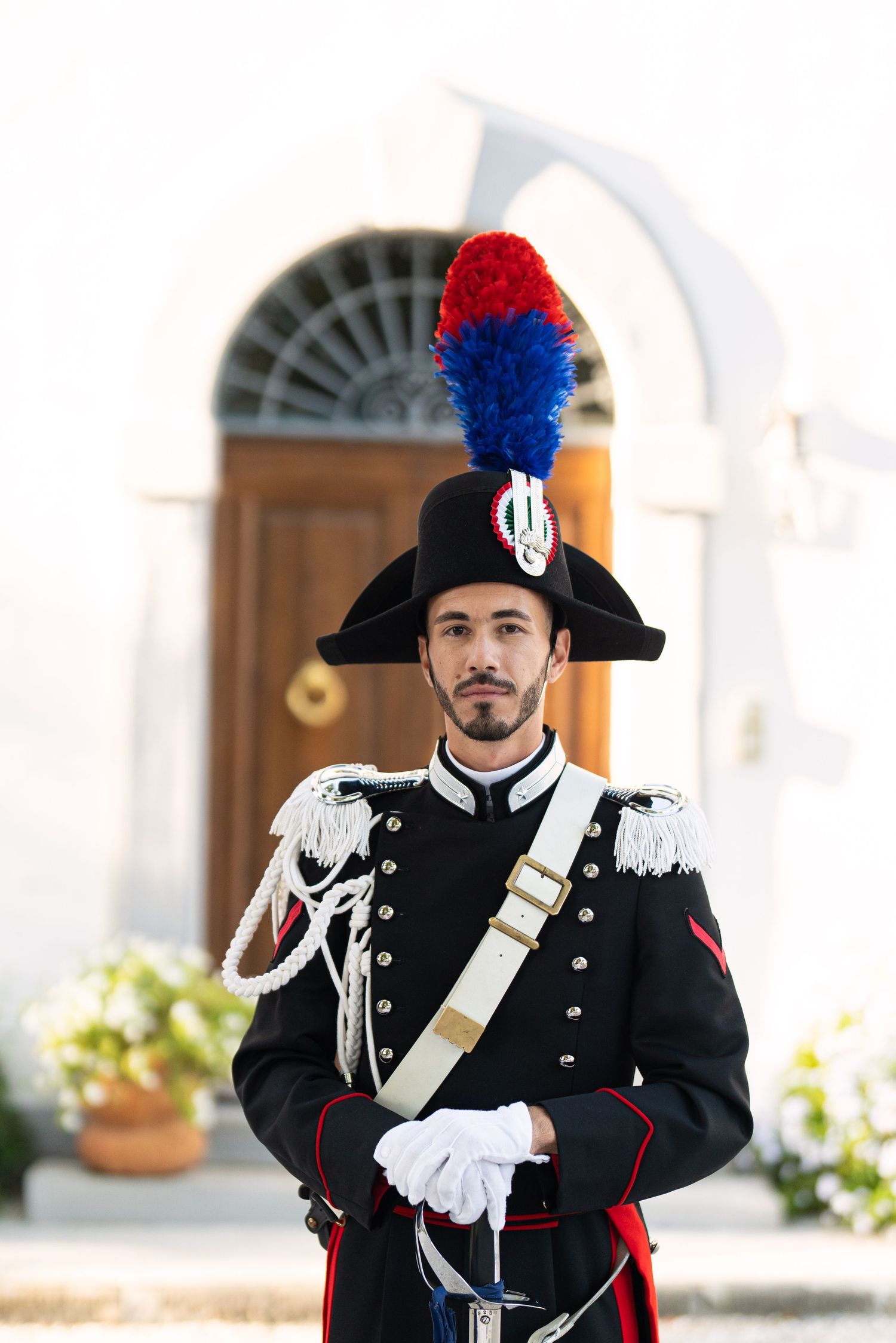 Traditional Italian carabinieri officer in ceremonial uniform with plumed hat.