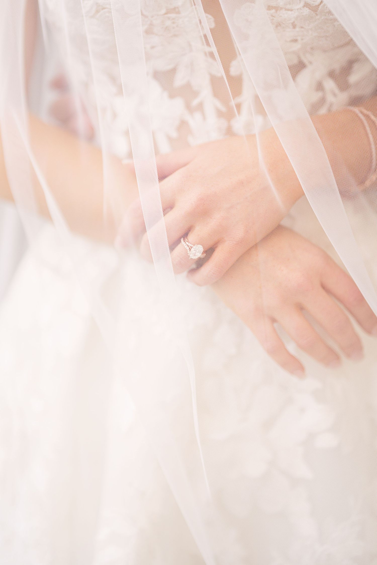 Close up detail of delicate white lace on wedding dress fabric.