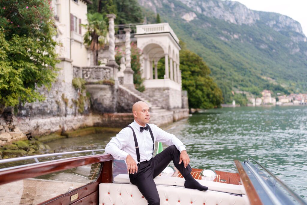 Scenic Italian villa terrace overlooking Lake Como with mountains and classical architecture.
