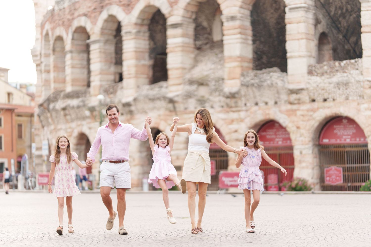 Verona family photographer family walking in front of Verona Arena Italy