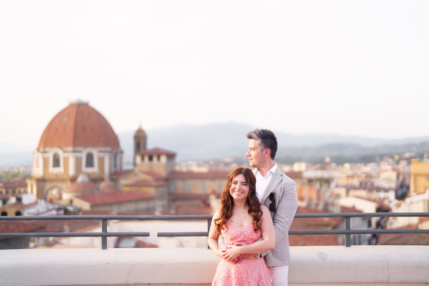 Romantic couple shares intimate moments against the backdrop of Florence, Italy's historic skyline and architecture.