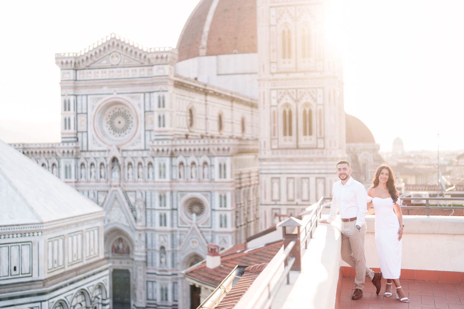 Romantic couple enjoying sunset view of Florence Cathedral and Duomo from rooftop terrace in Italy.