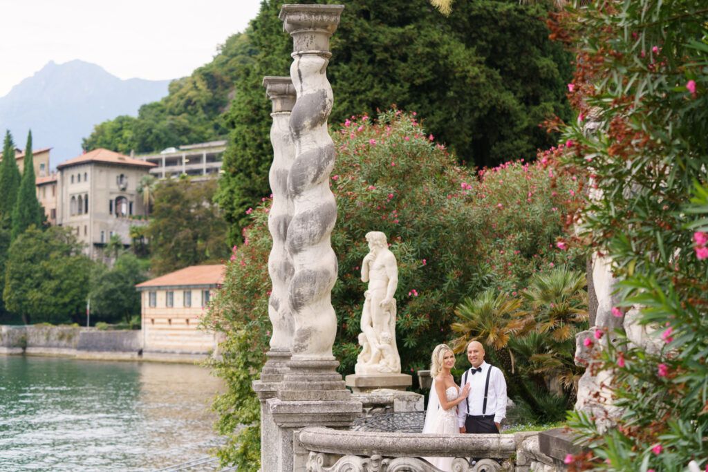 Scenic view of Lake Como with historic villa statues and gardens.