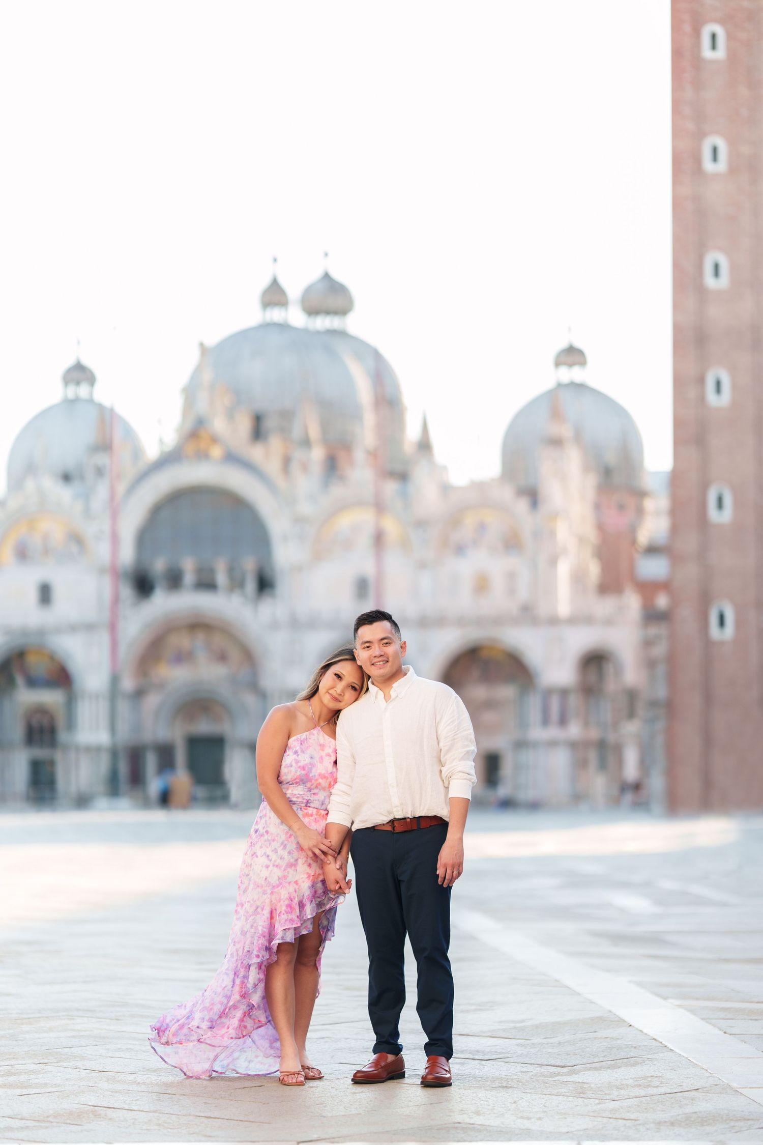 Couple posing in St. Mark's Square, Venice, with the iconic Basilica di San Marco in the background.