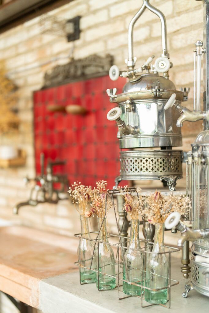 Vintage-style glass lanterns and dried flowers arranged on a rustic wooden surface.