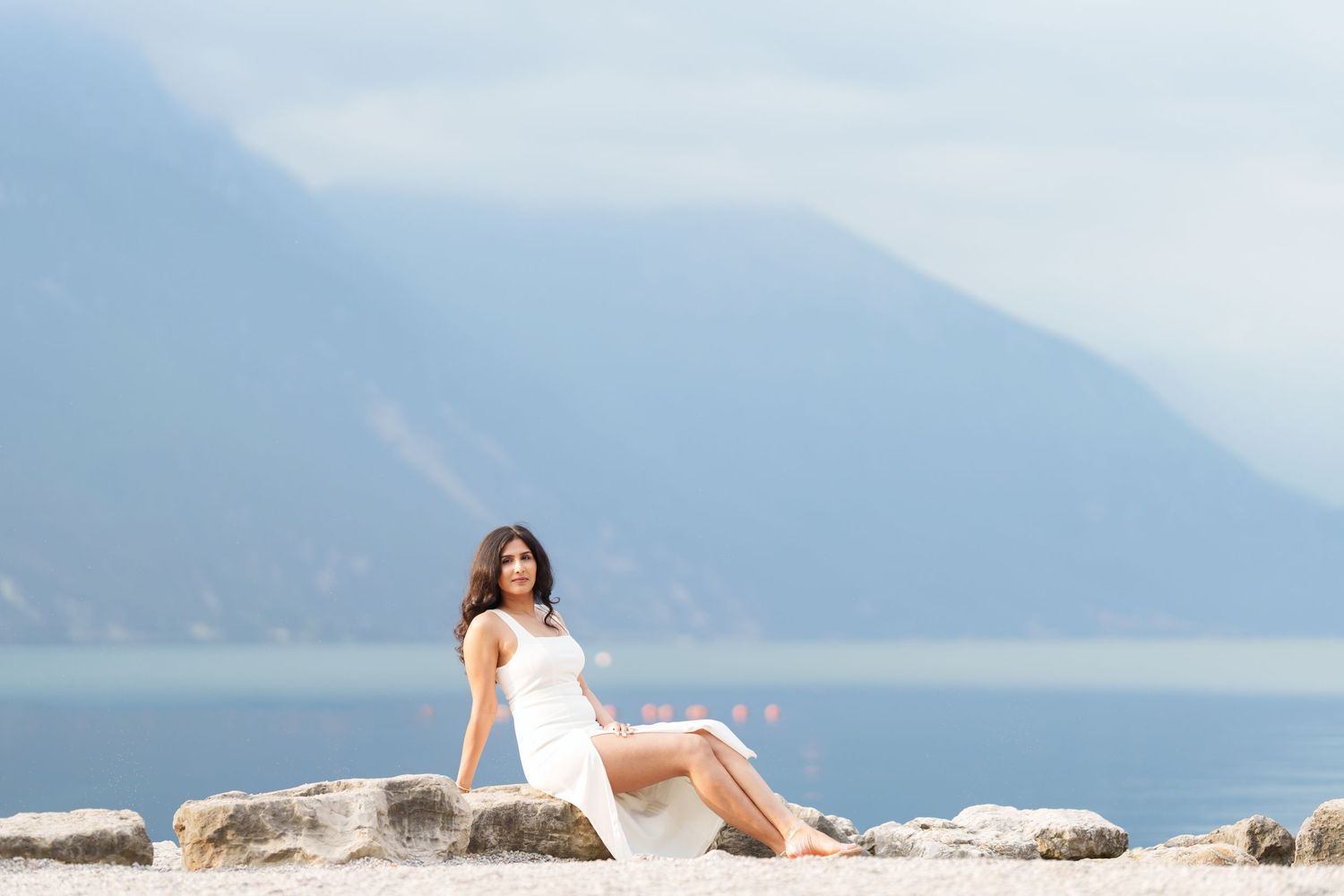 Scenic mountain lake views with a rocky shoreline and misty peaks in the distance.