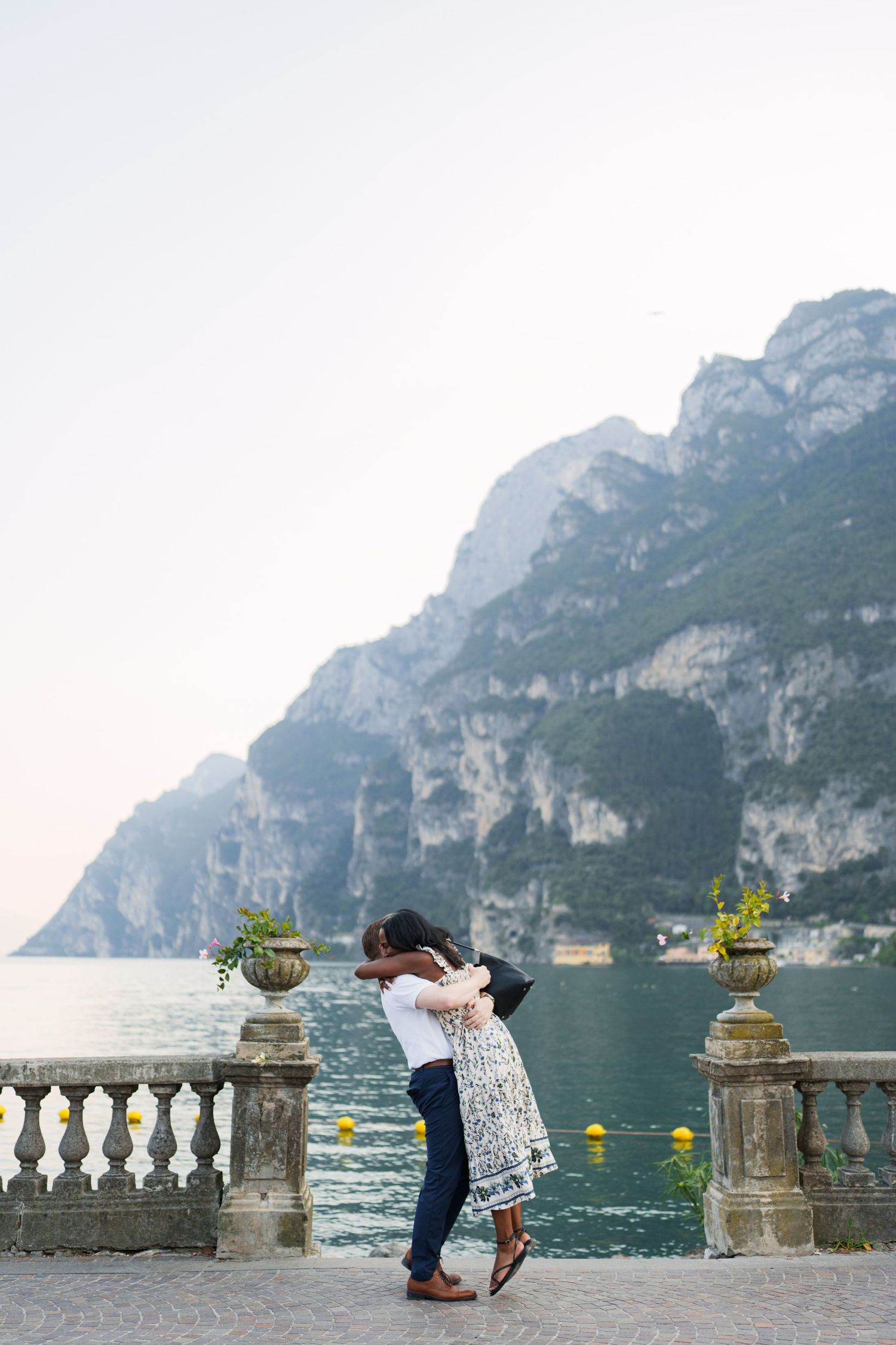 Couple walking together along the waterfront after their proposal in Riva del Garda