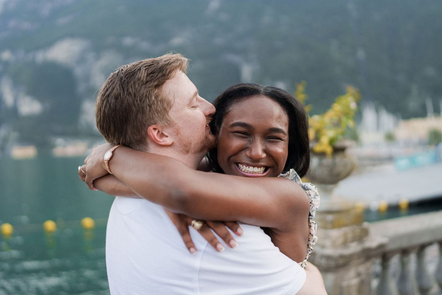 Engaged couple embracing beside Lake Garda during their Riva del Garda proposal session