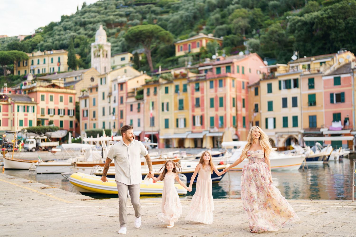 Scenic coastal views of colorful buildings along the Italian Riviera waterfront in Portofino with people enjoying the beach.