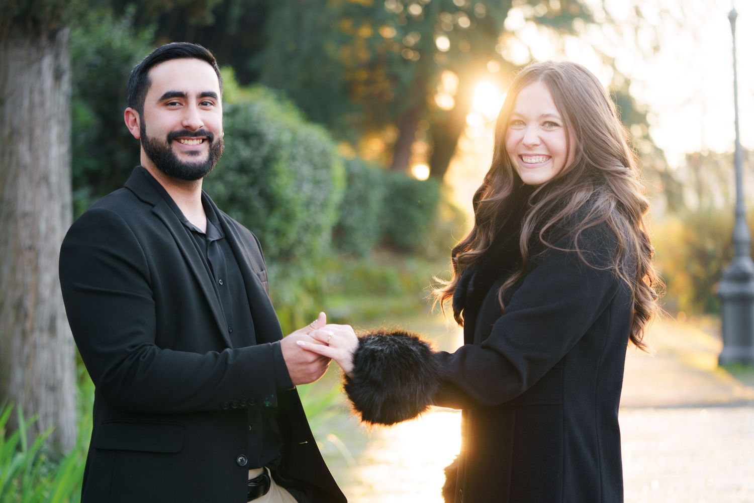 A couple shares joyful moments together during a golden hour outdoor photoshoot in a natural setting.