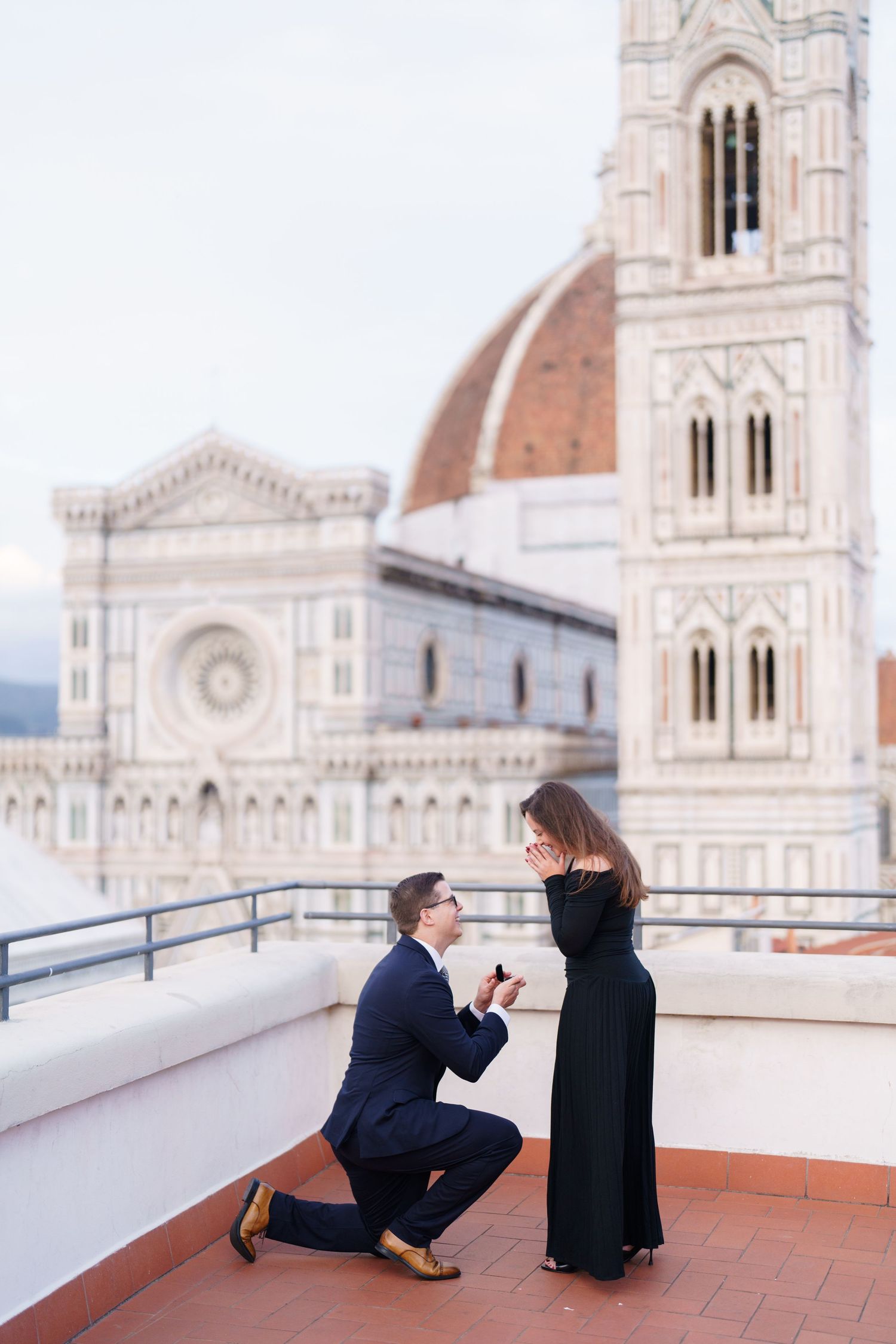 A romantic proposal moment unfolds on a terrace overlooking the Florence Cathedral and Duomo in Italy.