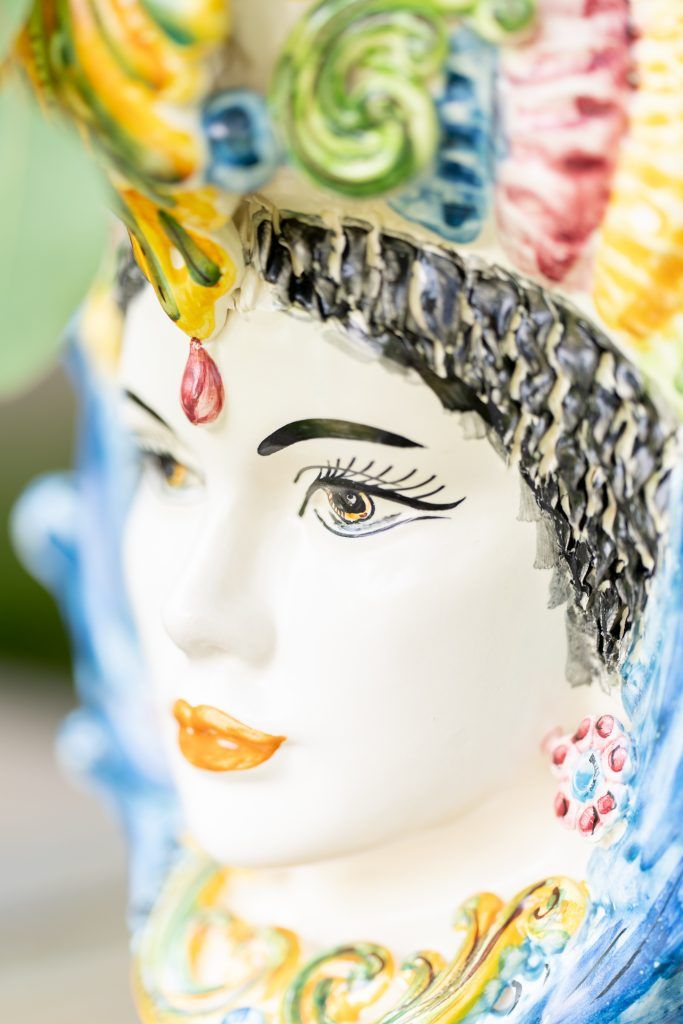 Decorative ceramic head vase with ornate details and colorful painted features.