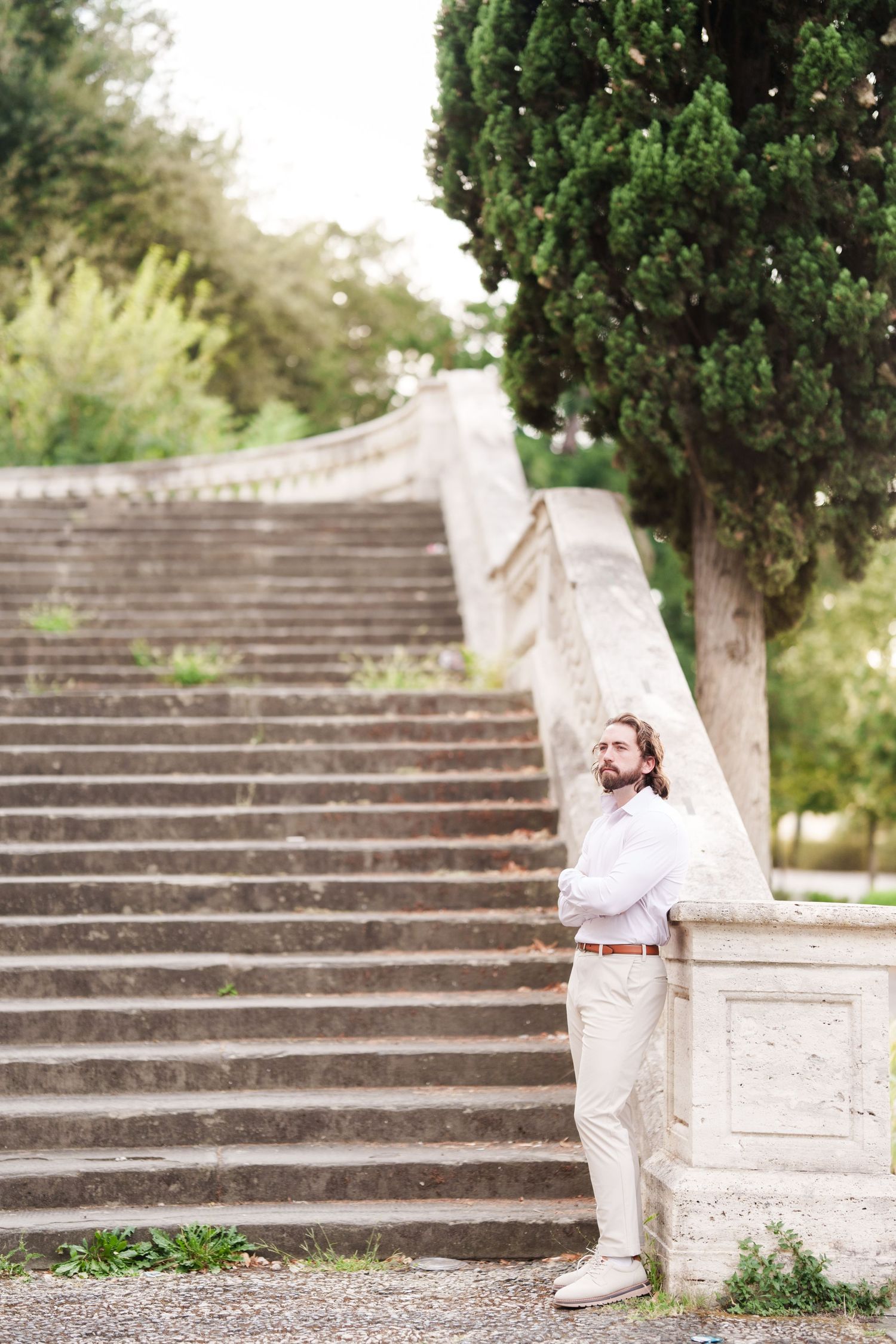 Stone steps with cypress trees in a Mediterranean garden create an elegant outdoor setting for a photoshoot.