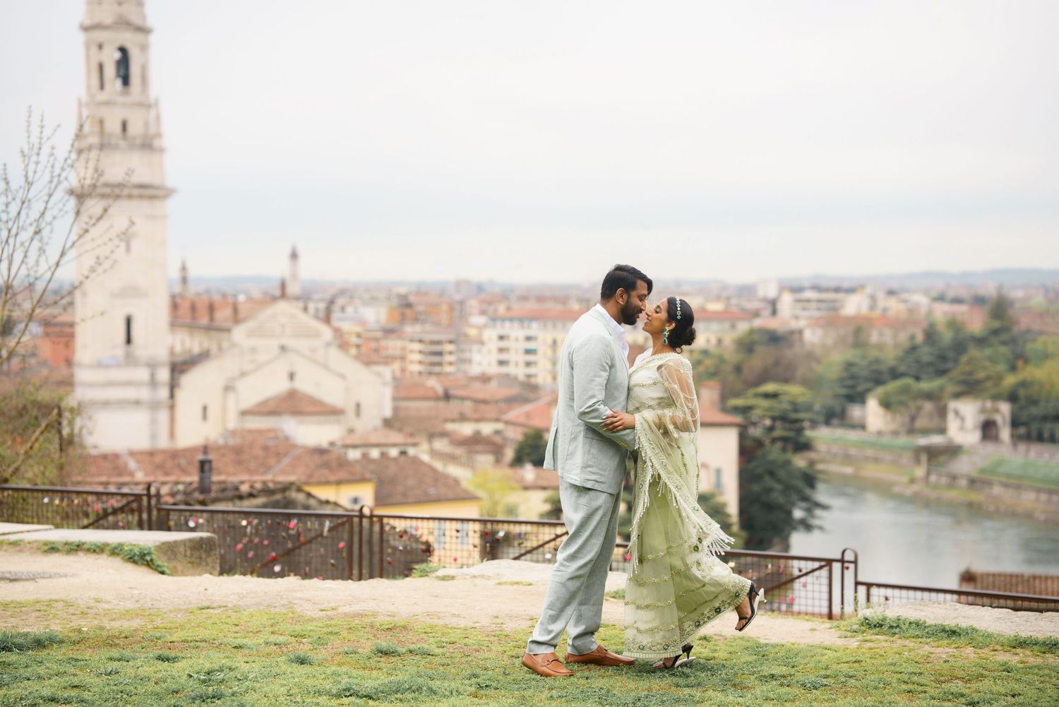 A couple shares a romantic moment overlooking the historic cityscape of Florence, Italy from a scenic viewpoint.