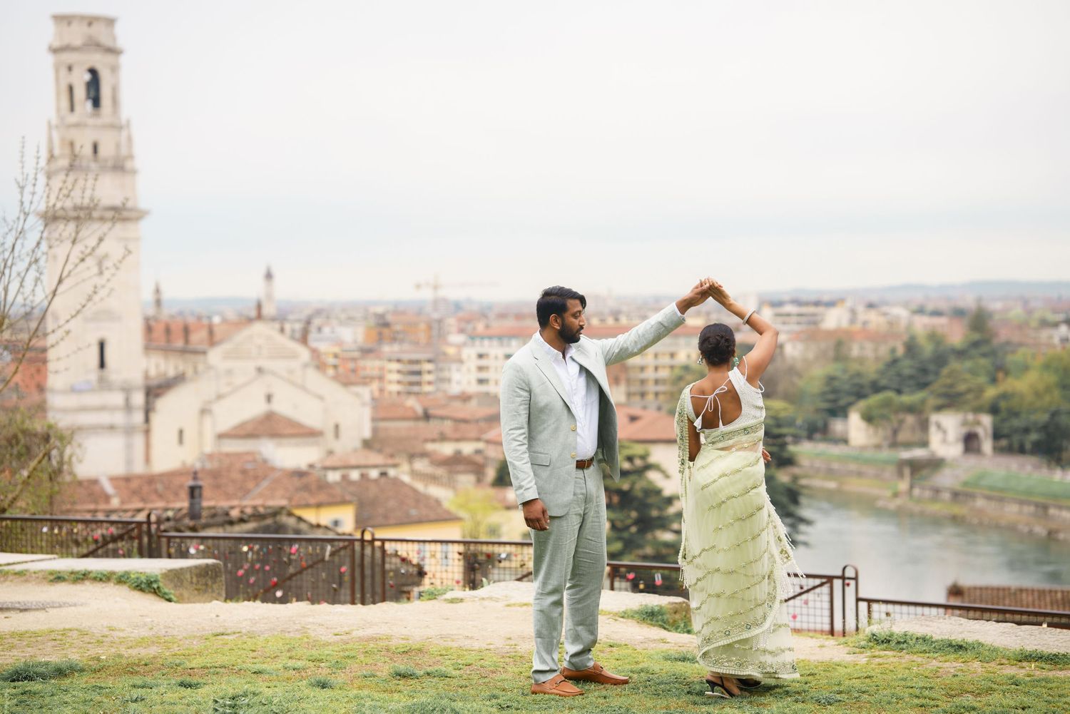 A romantic couple shares tender moments against the scenic backdrop of historic European architecture and city views.