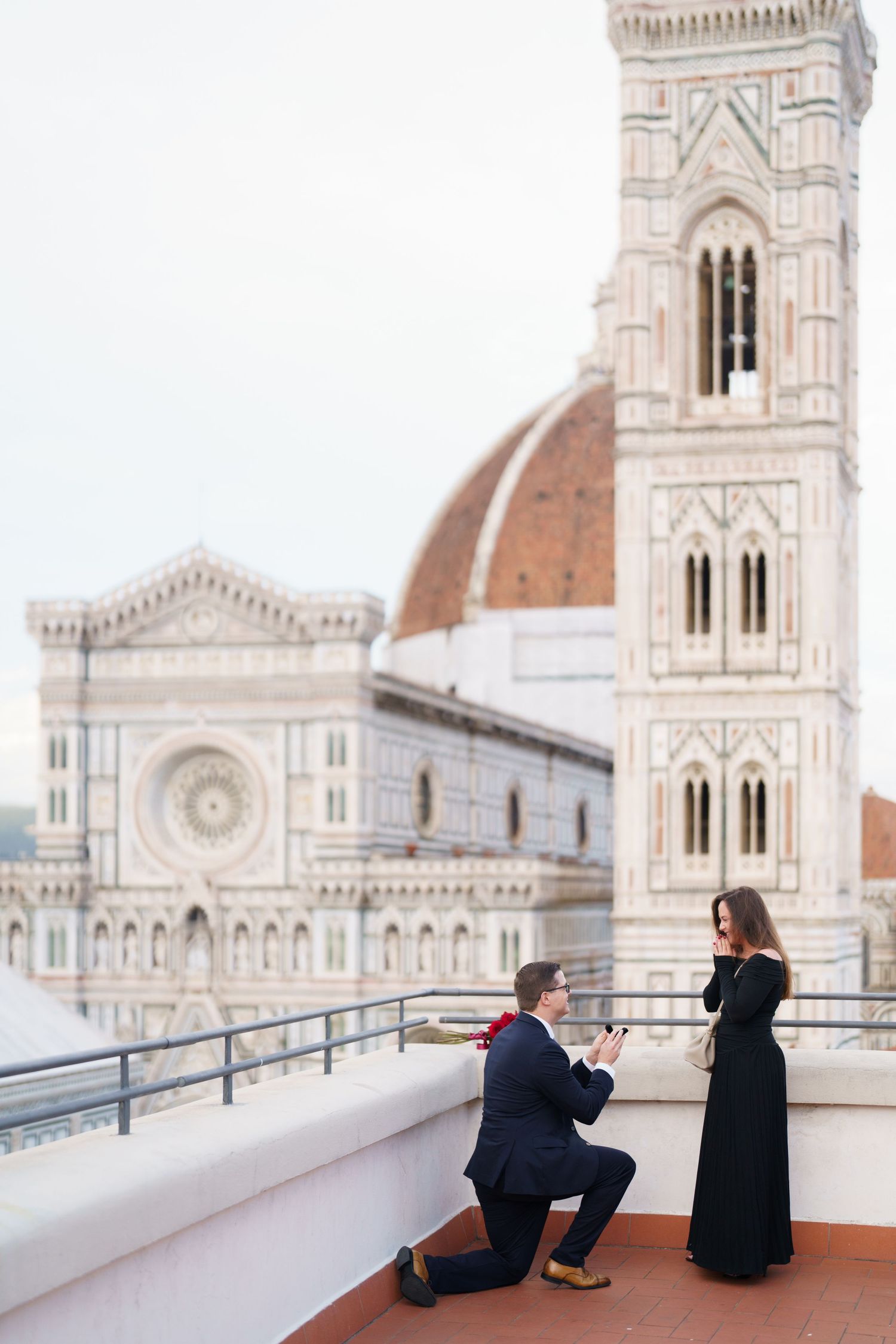 A romantic proposal moment on a terrace overlooking the Florence Cathedral and Giotto's Bell Tower in Italy.