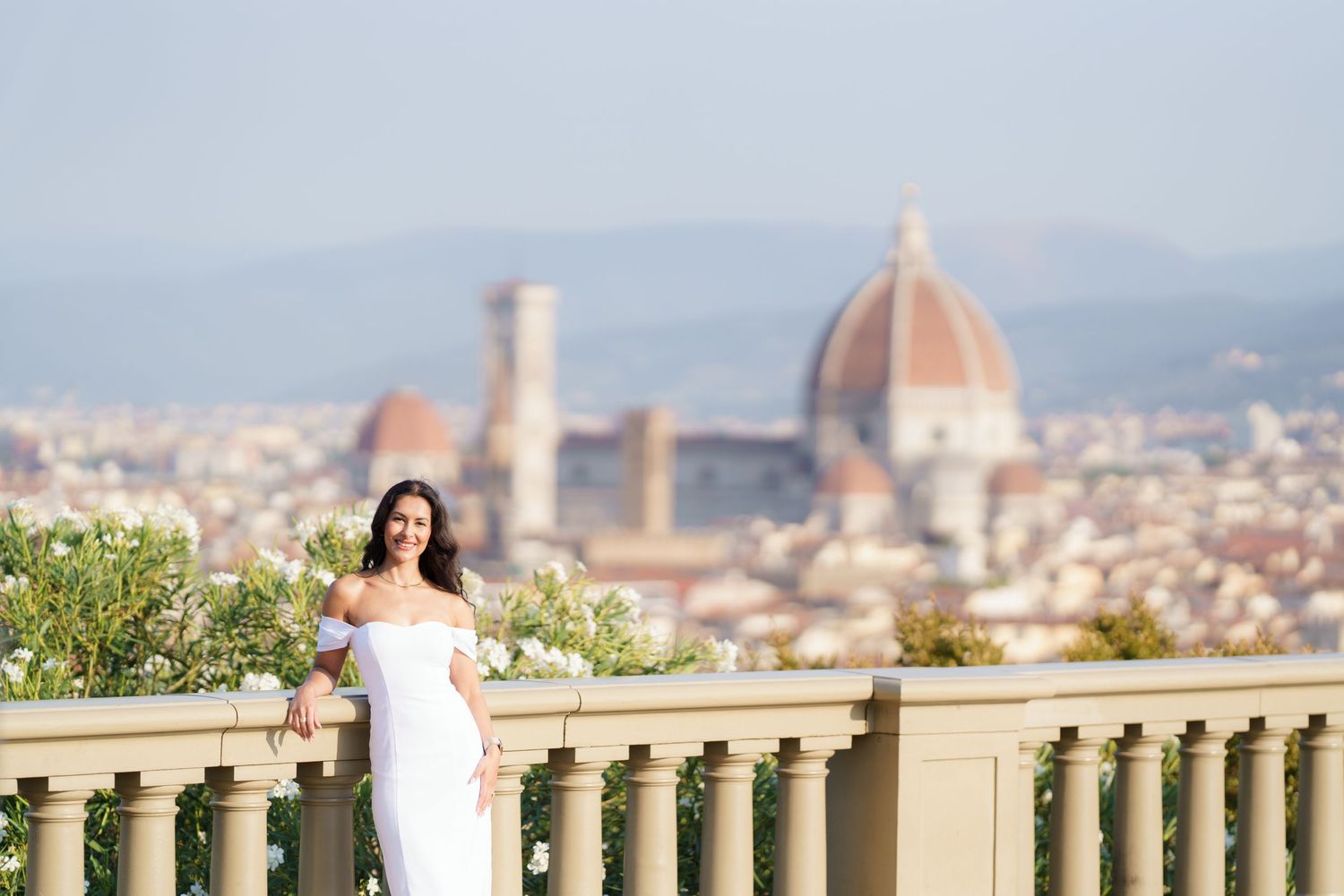 A scenic view of Florence Italy with the iconic Duomo cathedral dome visible from a terrace overlook.