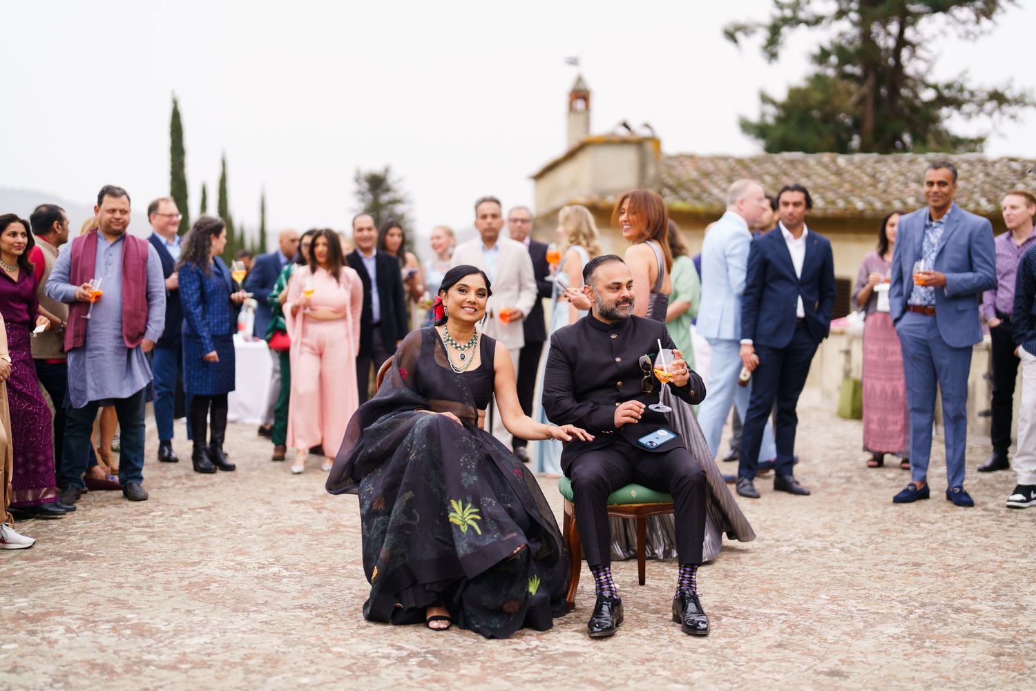 Wedding celebration at an outdoor venue with guests mingling on a stone patio.